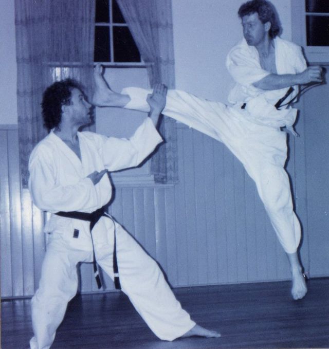 Two men practising martial arts in a room