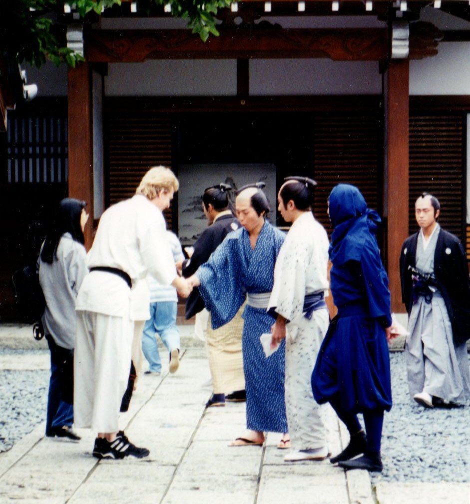 A group of people standing on a sidewalk in front of a building