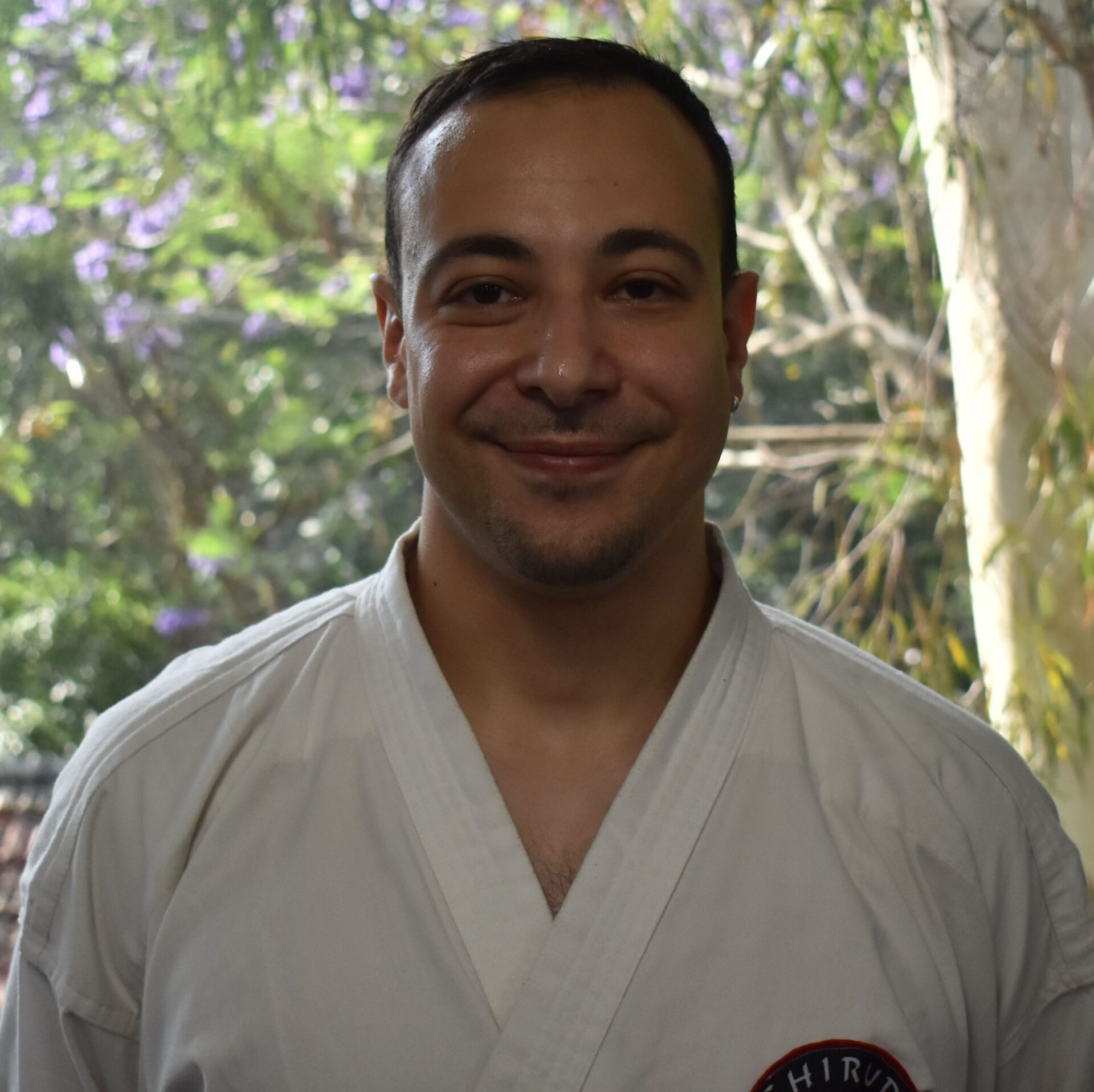 A man wearing a white shirt with the word karate on it