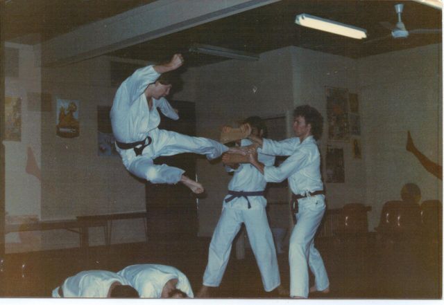 A group of people practising martial arts in a gym