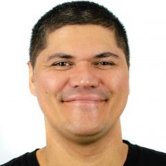 A man in a black shirt is smiling for the camera.