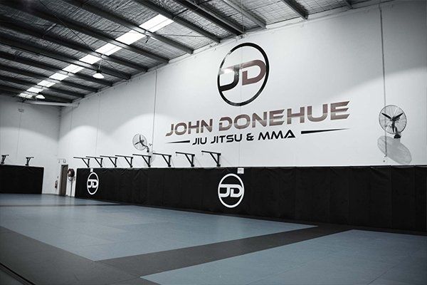 A black and white photo of a gym with a logo on the wall.