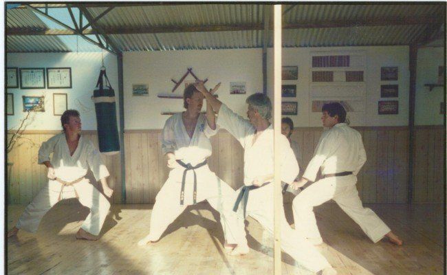 A group of men are practicing karate in a gym