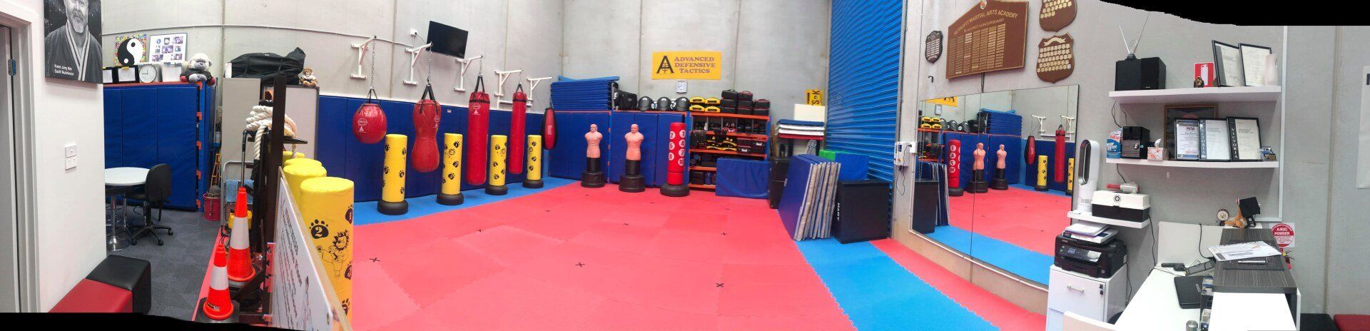A picture of a gym with a red and blue mat and a mirror.