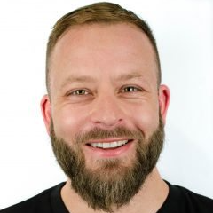 A man with a beard is smiling for the camera.