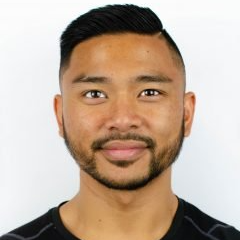 A man with a beard is smiling and wearing a black shirt.