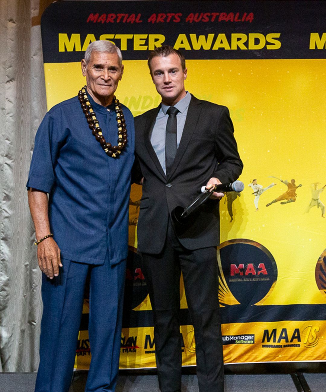 Two men standing in front of a banner that says martial arts australia master awards