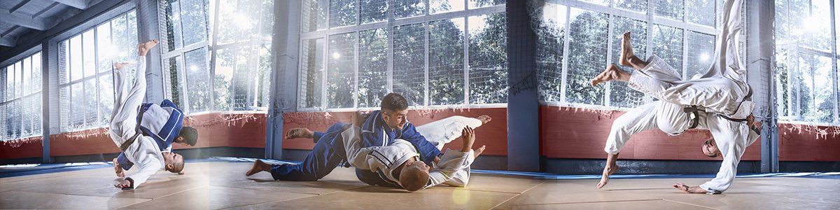A group of people are practicing karate in a gym.