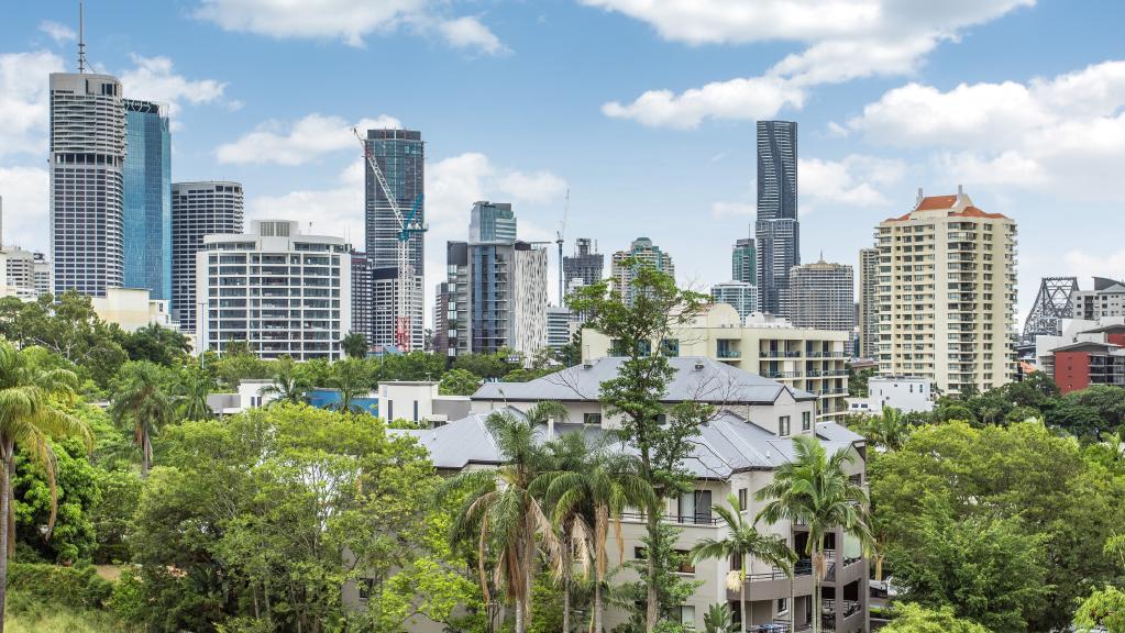 A city skyline with a lot of buildings and trees in the foreground.