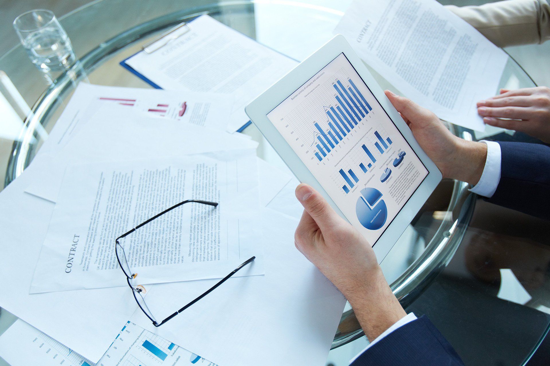 A person is holding a tablet with a graph on it.
