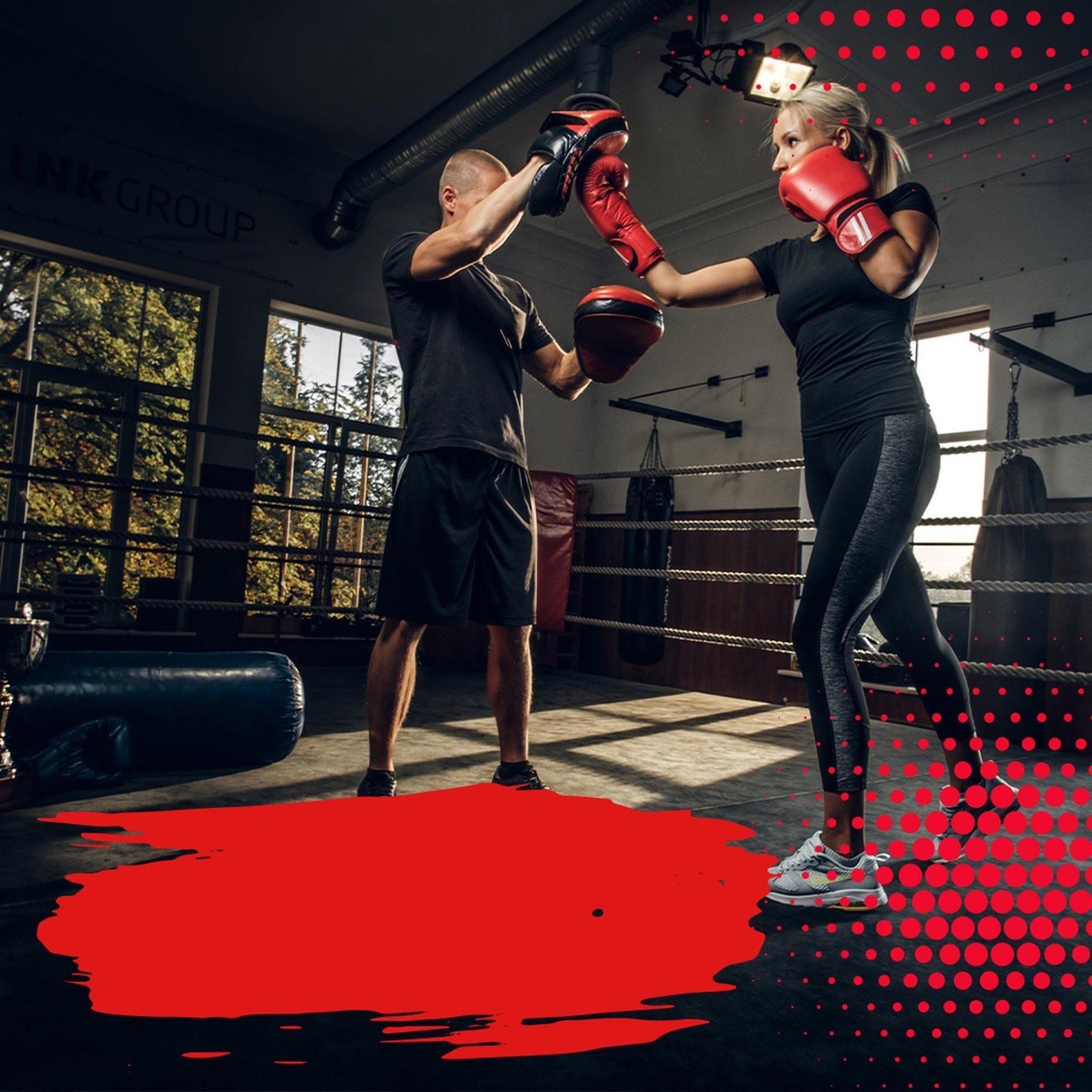A man and a woman are boxing in a gym.