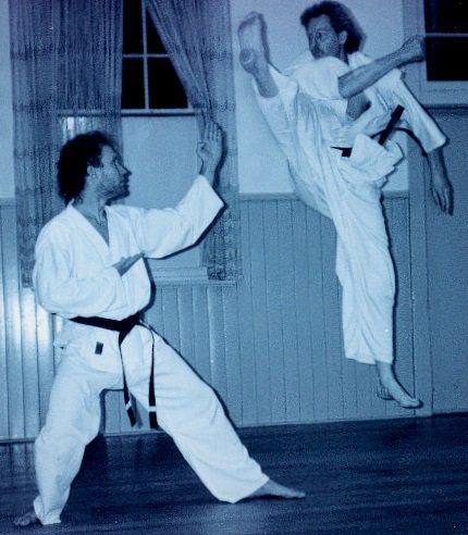 Two men practising martial arts in a room