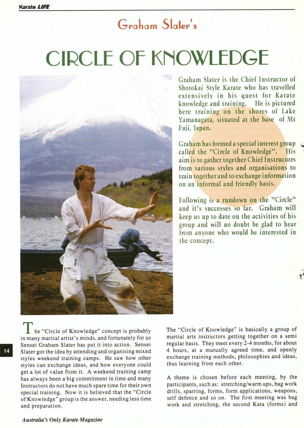 A man in a white karate uniform is standing on a beach.