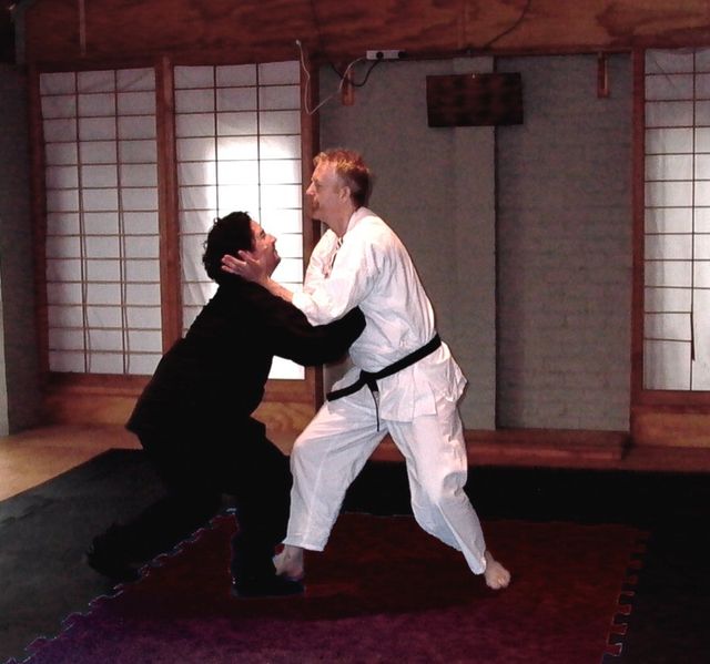 Two men practising martial arts in a gym