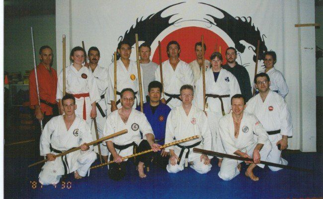 A group of men in karate uniforms pose for a photo