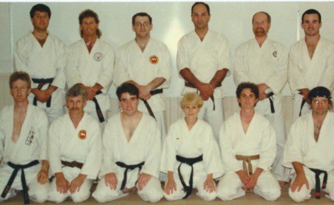 A group of people in karate uniforms are posing for a picture