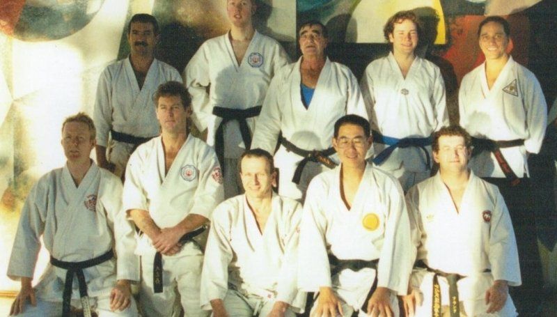 A group of martial arts instructors in uniform posing together