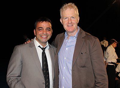 Two men in suits and ties are posing for a picture.