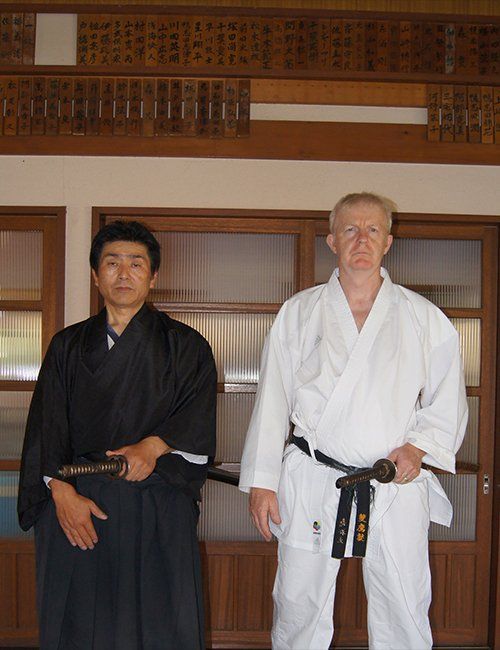 Two men in karate uniforms are standing next to each other