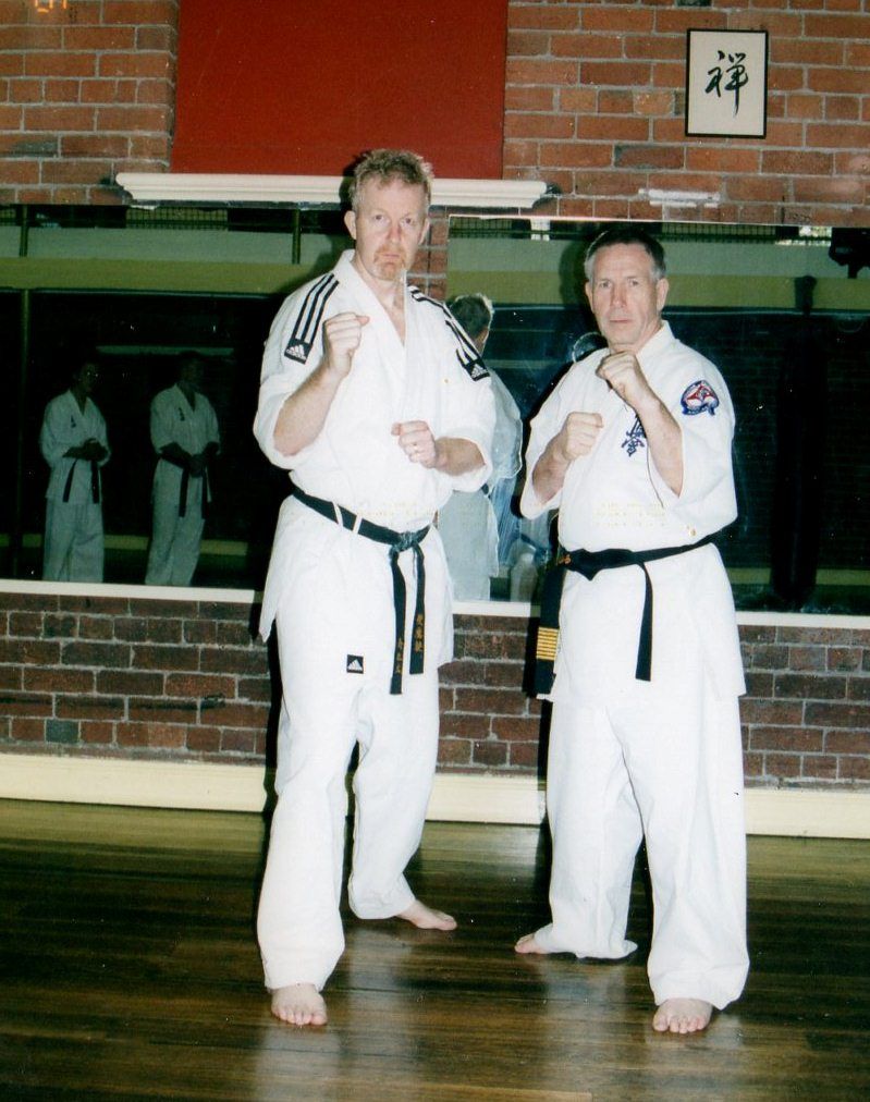 Two men in karate uniforms are standing next to each other