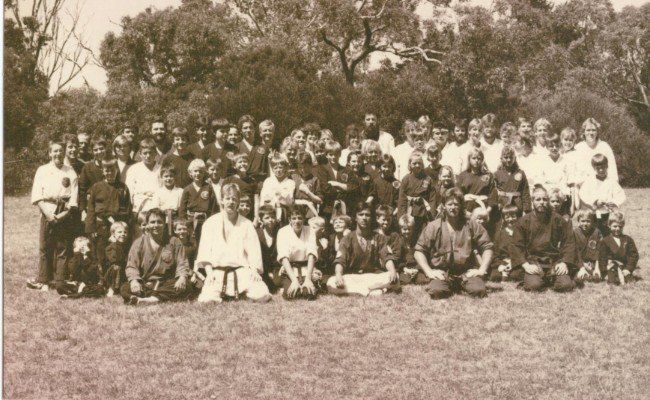 A group of people are posing for a picture in a field.