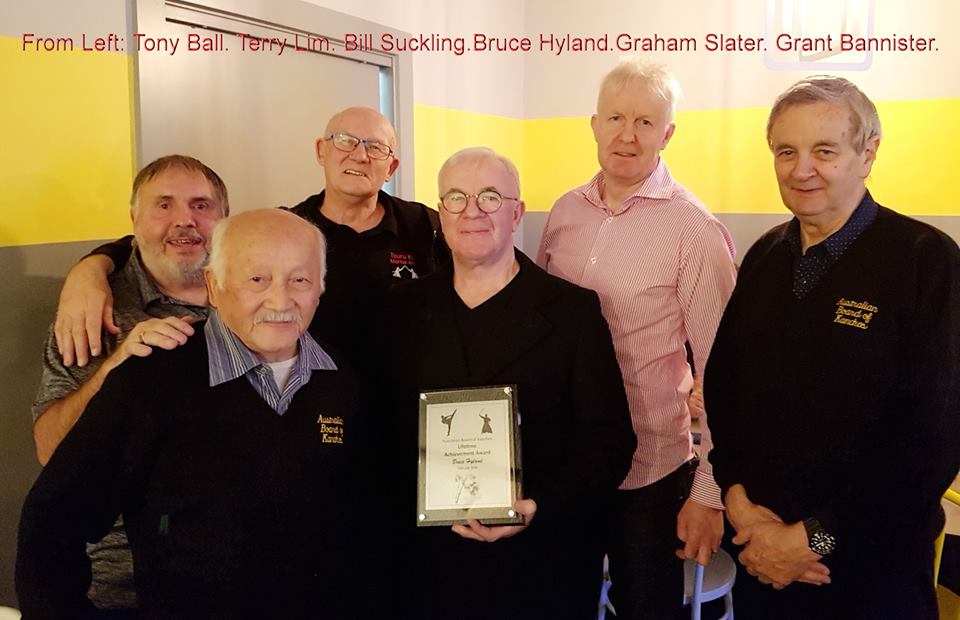 A group of men are posing for a picture and one of them is holding a certificate