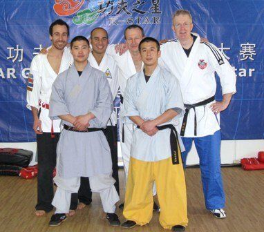 A group of martial arts fighters pose for a photo