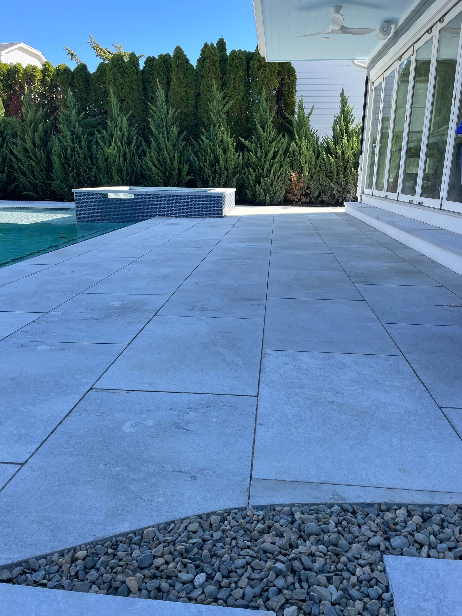 A patio with a swimming pool in the background