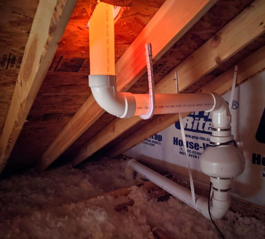 A white pipe is hanging from the ceiling in a room with a sign that says rite