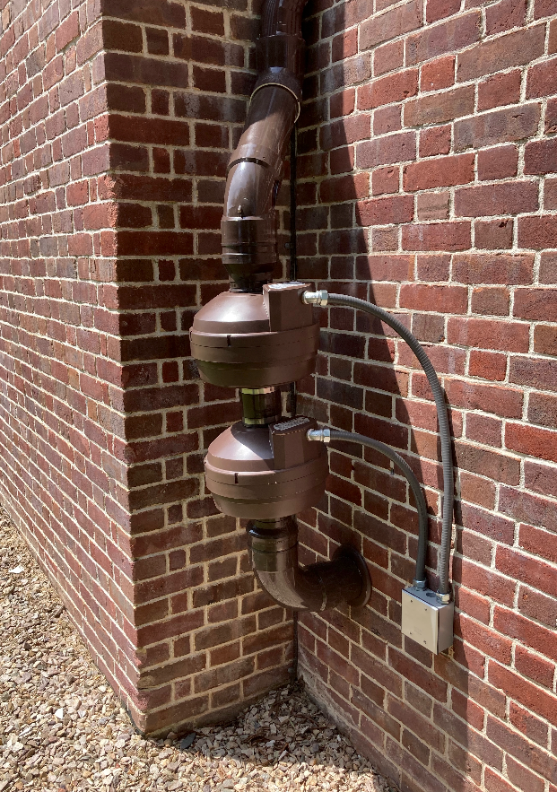 A brick wall with a pipe attached to it.