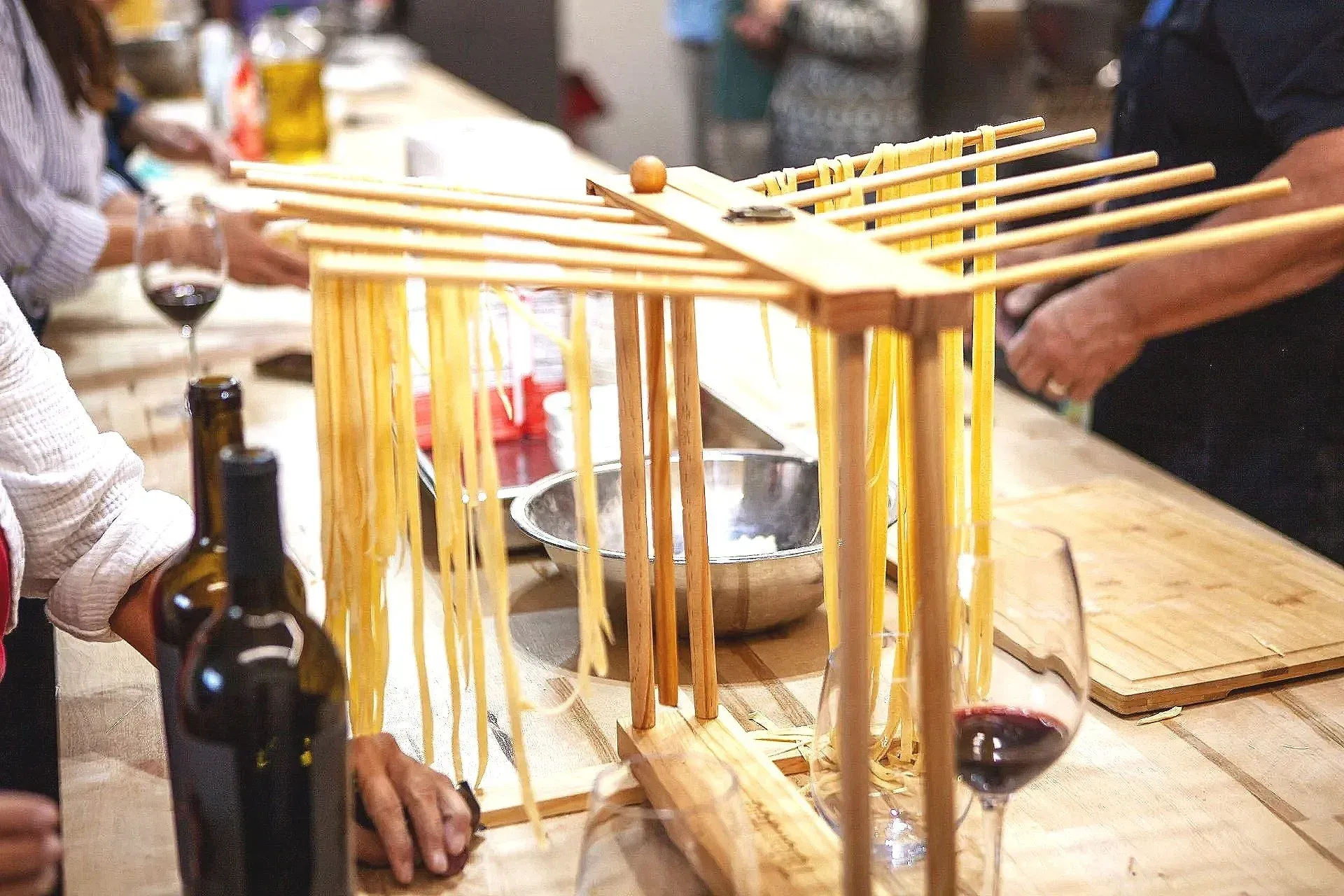 Hands shaping fresh pasta shapes on a wooden board