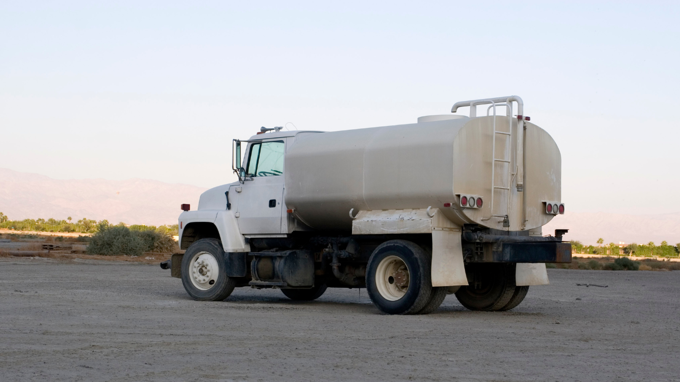 a water truck is parked on the side of the road