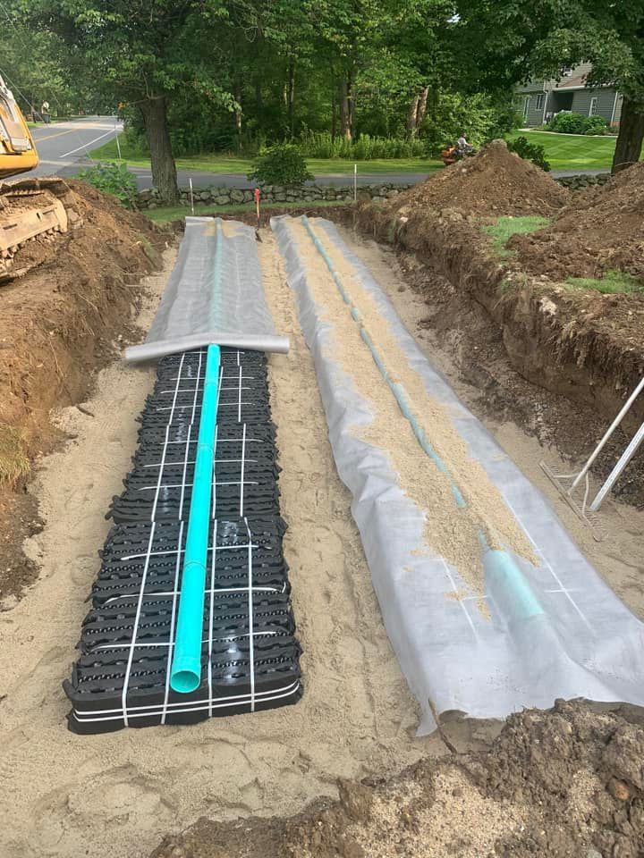 A drainage system is being built in the dirt next to a road.