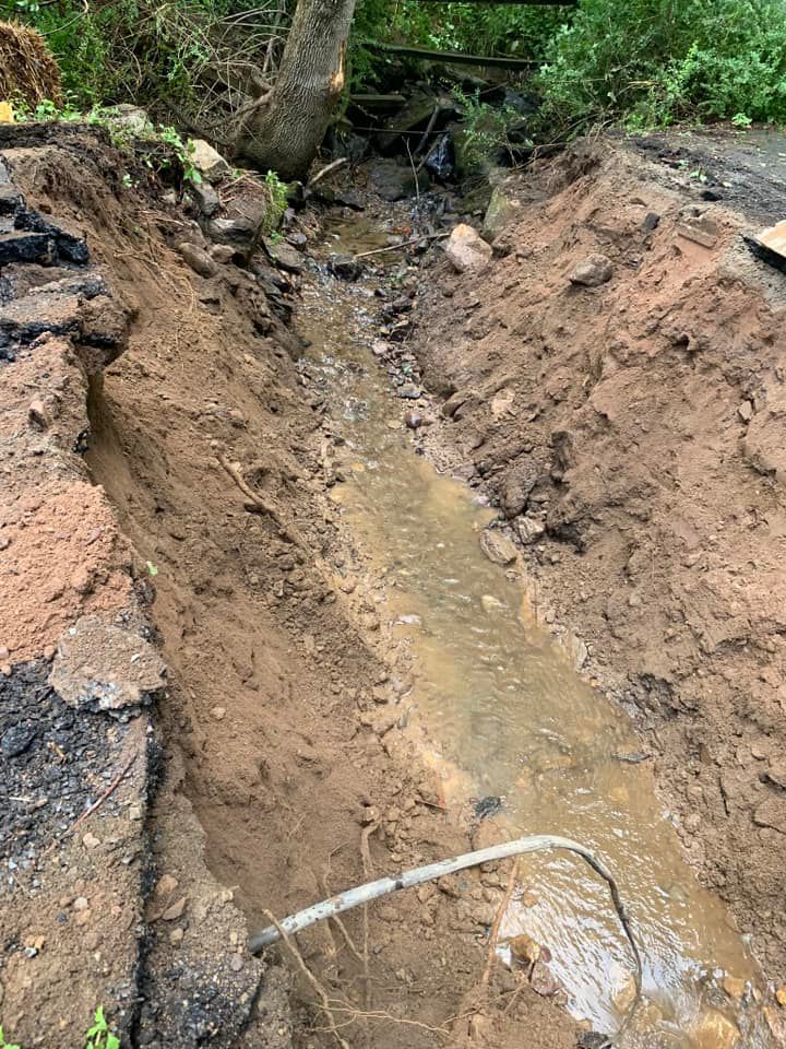 A stream of water is coming out of a hole in the ground.