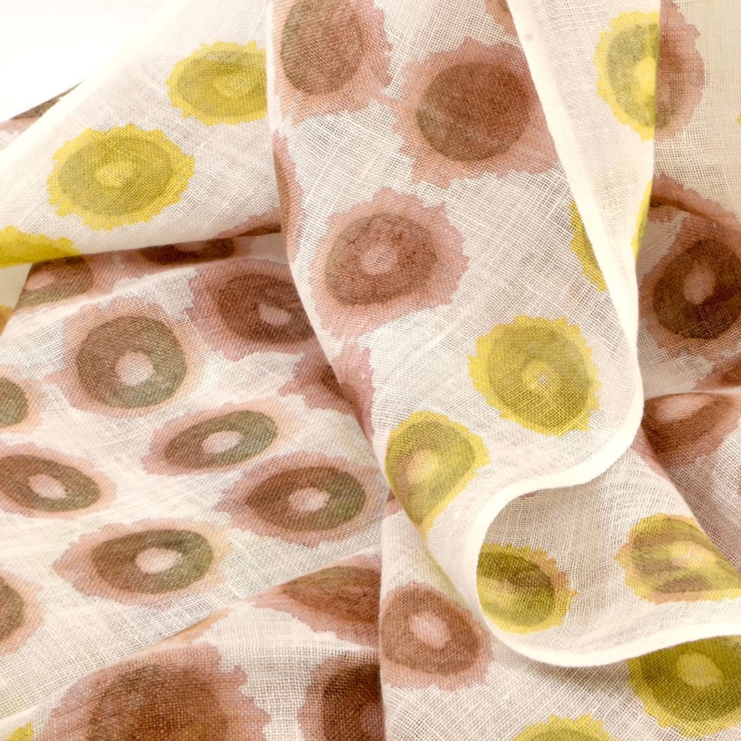 A fabric scarf with a pattern of rust-red and lime-green circles