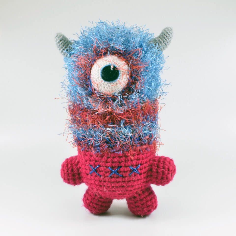 soft sculpture monster with one eye, horns, and bright blue and red fur