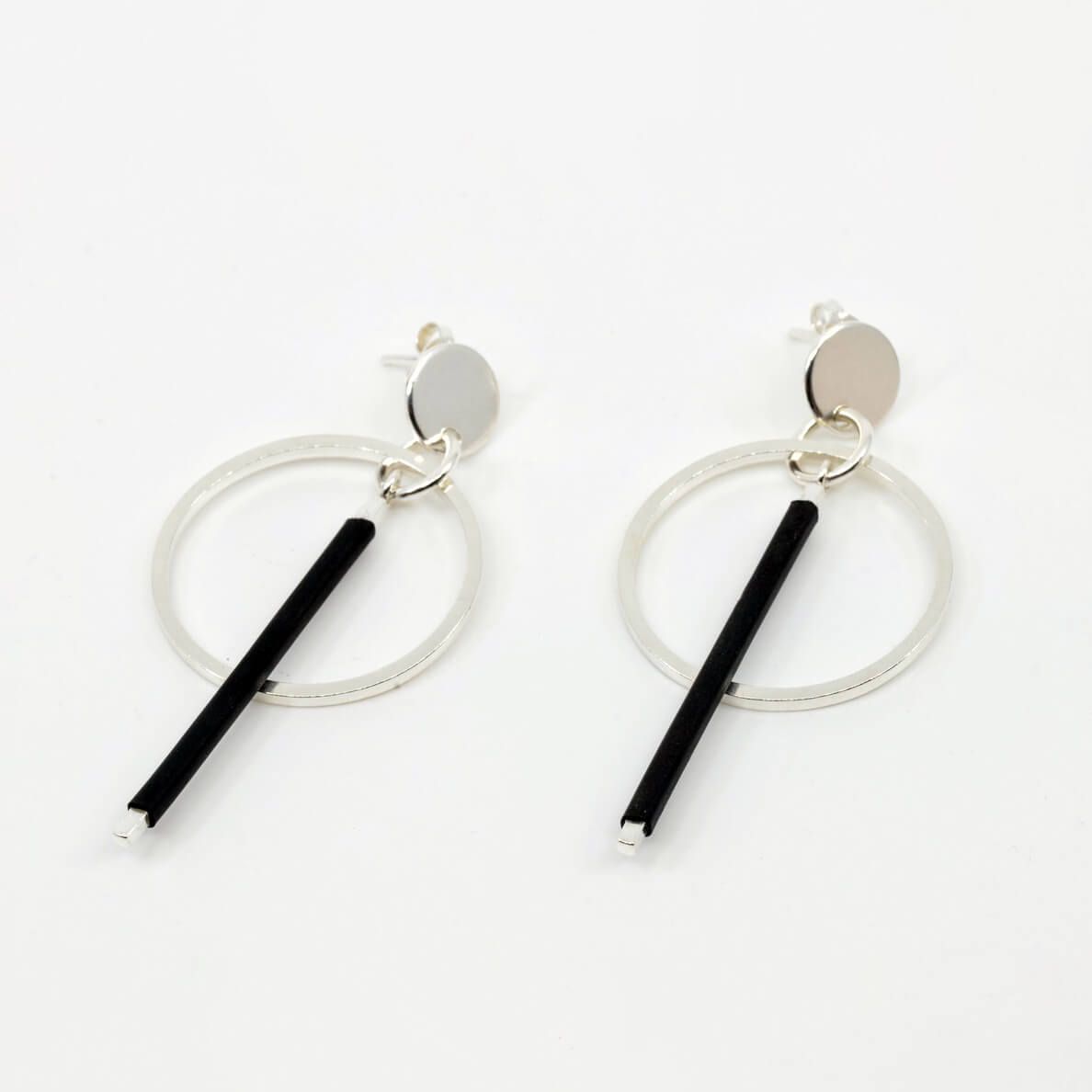 a pair of earrings in silver with black rubber embellishments