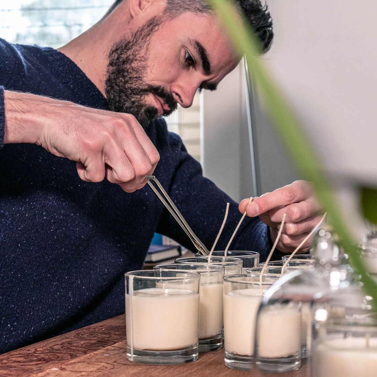 Thomas Hingant trims the wicks of his handmade candles