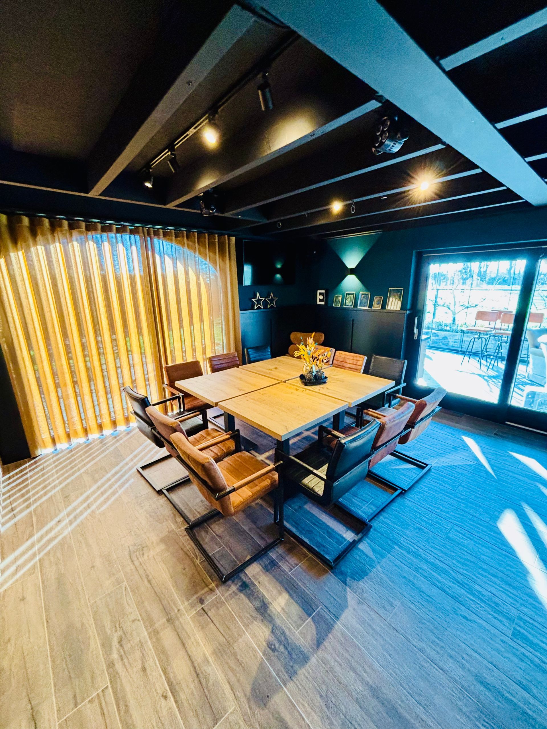 Moderne eetkamer met een houten tafel, comfortabele stoelen, warme verlichting en grote ramen met een helder uitzicht.