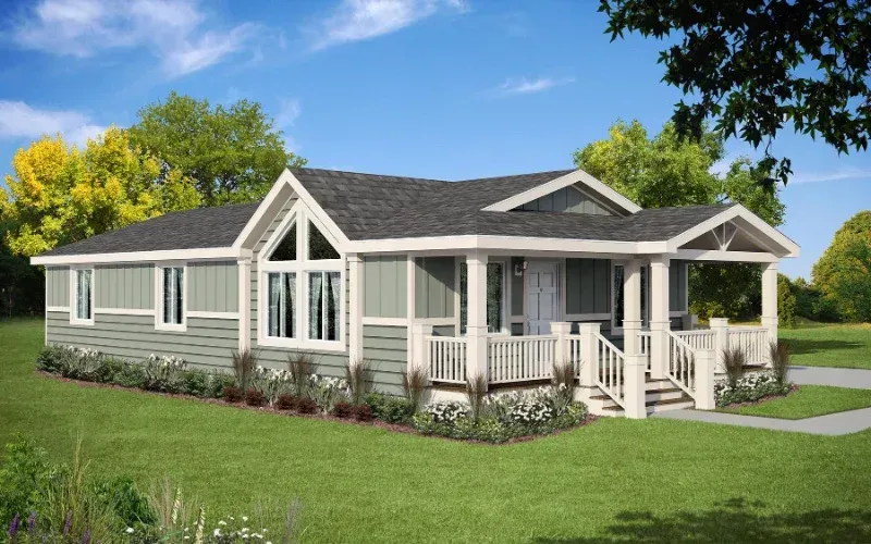 Single-story gray house with white trim and porch, set on a green lawn under a blue sky.