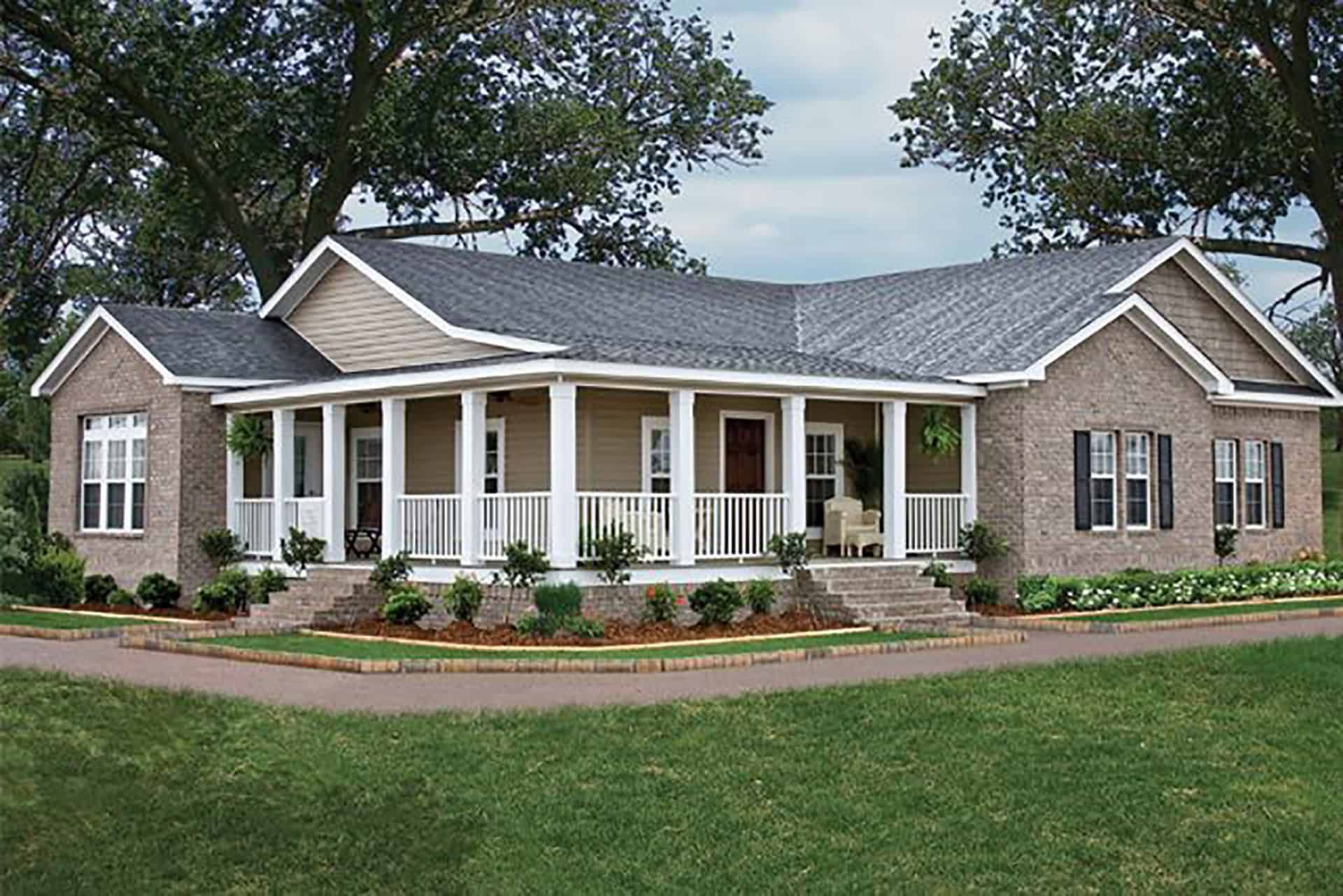 Single-story brick house with white porch and columns, surrounded by a green lawn and trees.