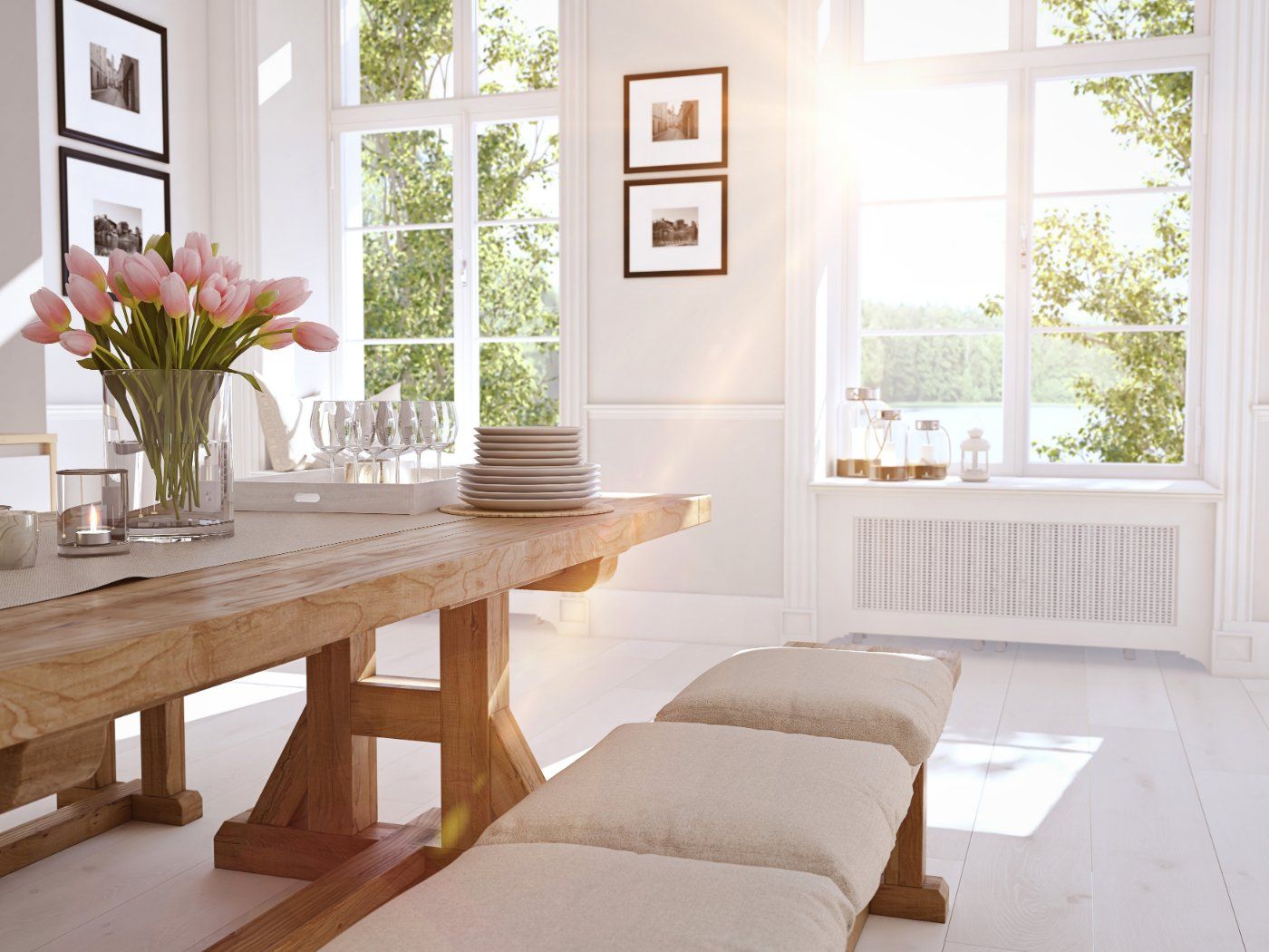 Bright dining room with wooden table, bench seating, large windows, and tulips.