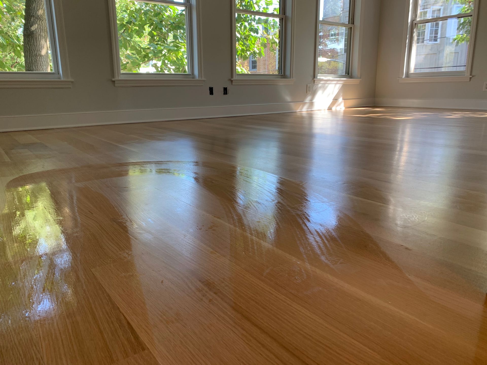 Gloved hand wipes a window frame clean with a yellow cloth.