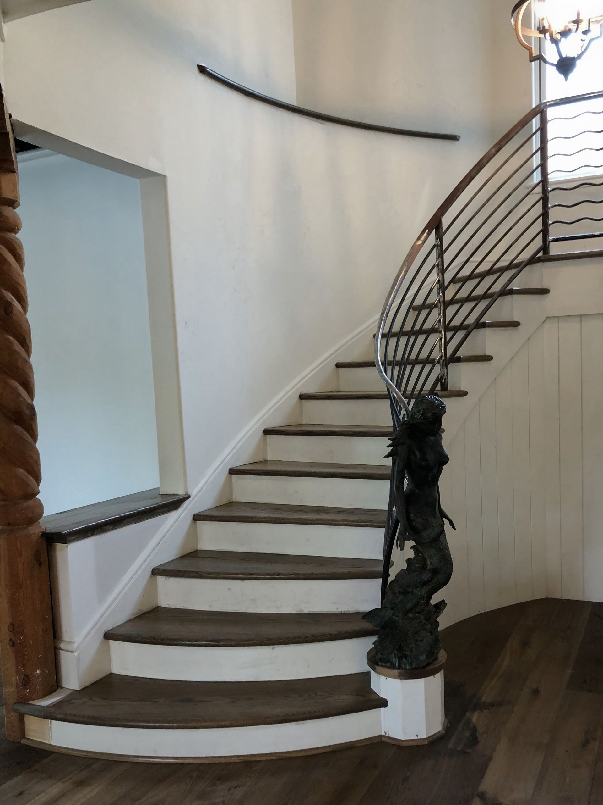 Person wearing yellow gloves sprays and wipes a window clean with a blue cloth.