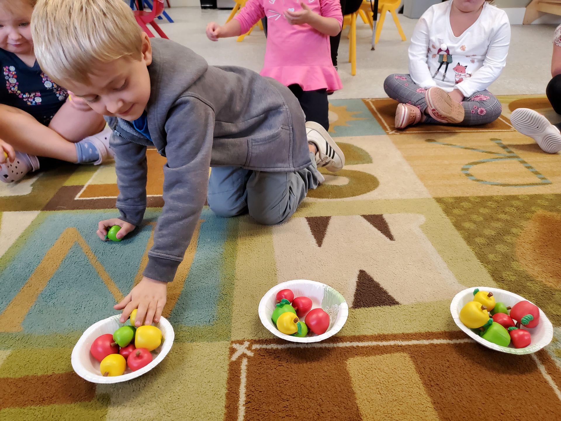 child picking fruits on plate