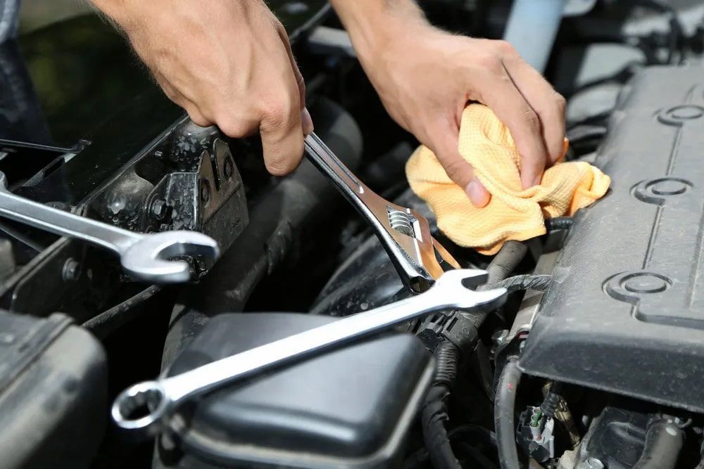 Mechanic Working on a Car Engine With Wrenches and a Yellow Rag — Cool Cars NT in Acacia Hills, NT