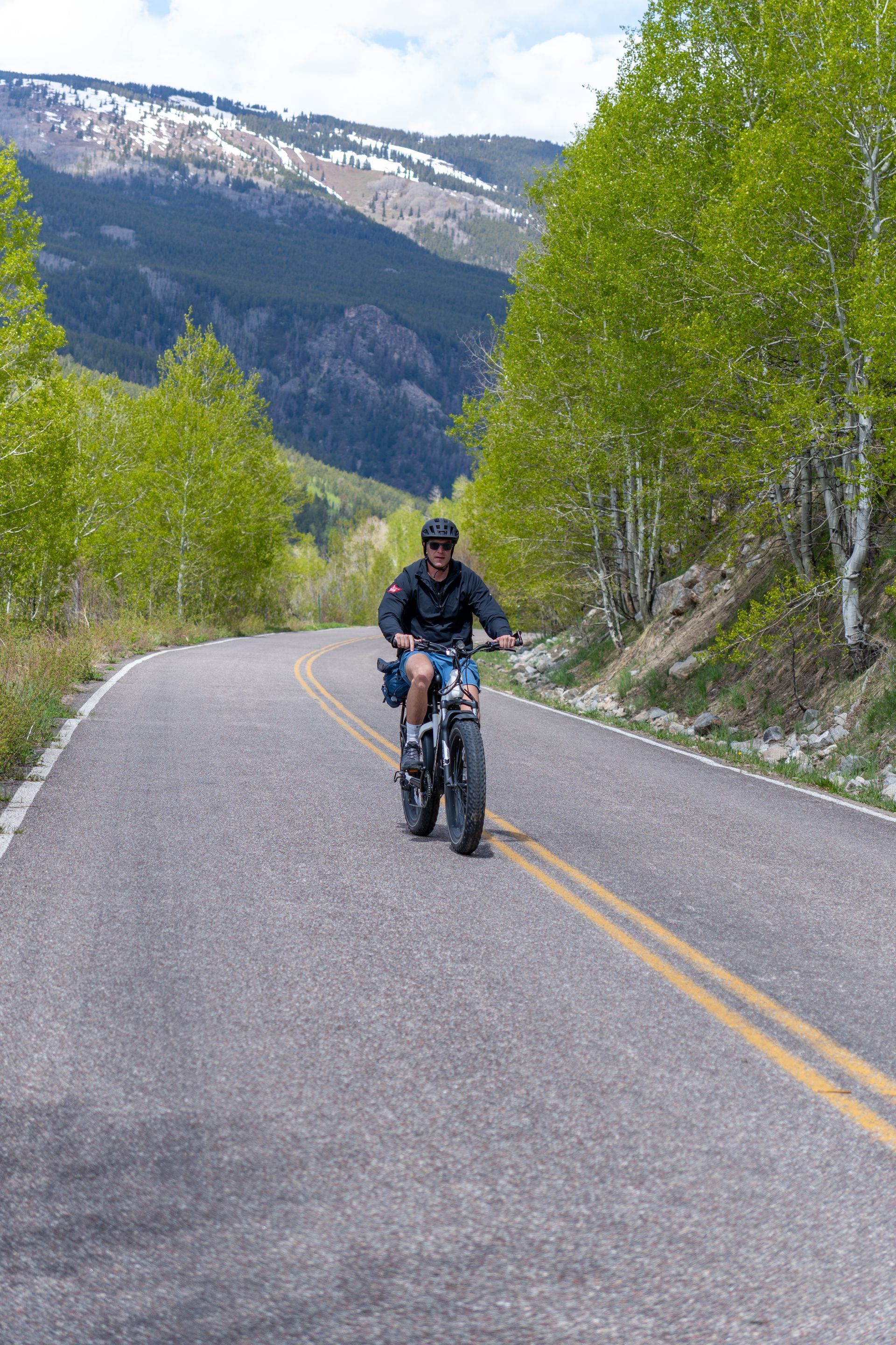 A woman is riding an electric bike in the woods.