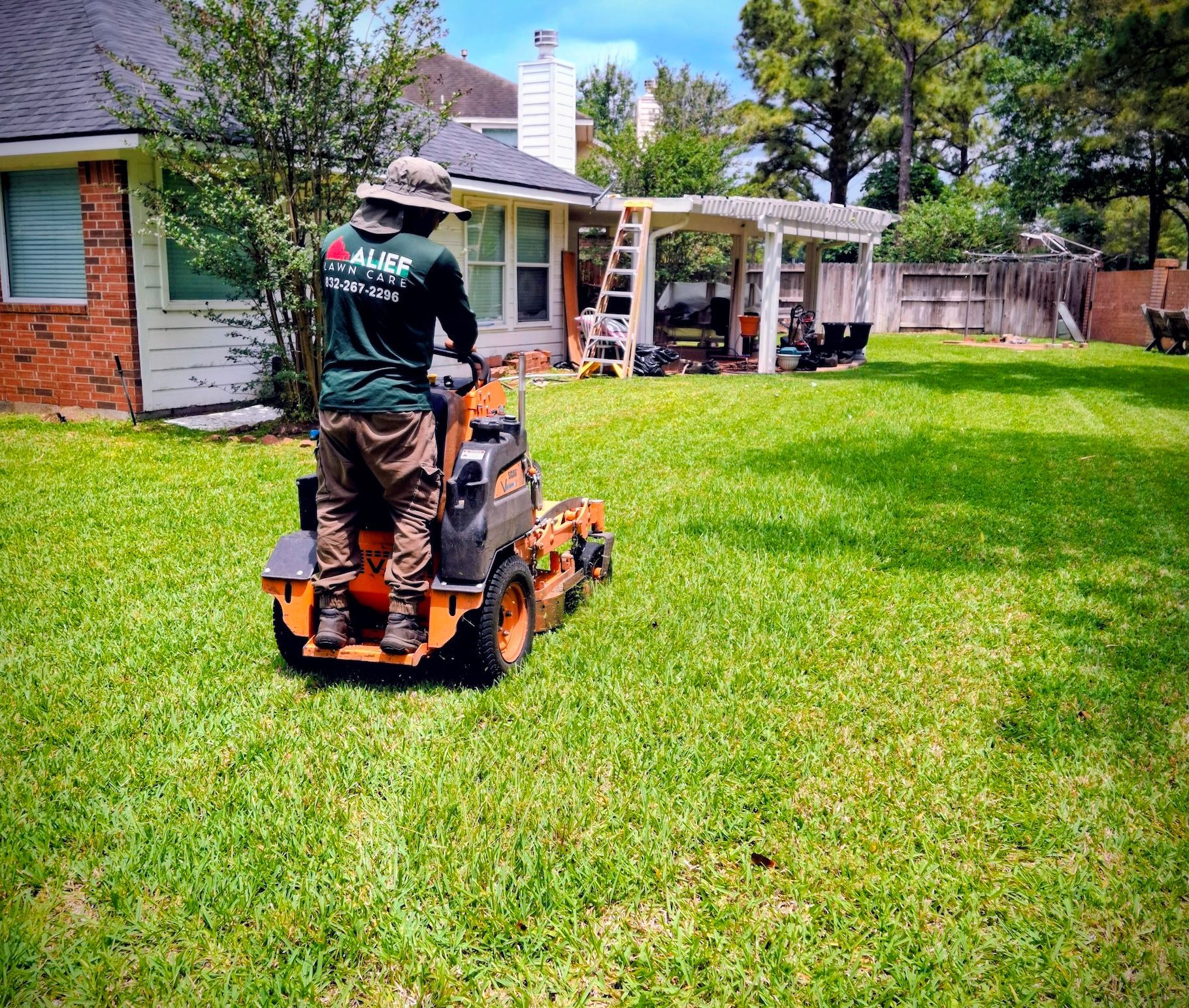 a man is riding a orangelawn mower on a lush green lawn