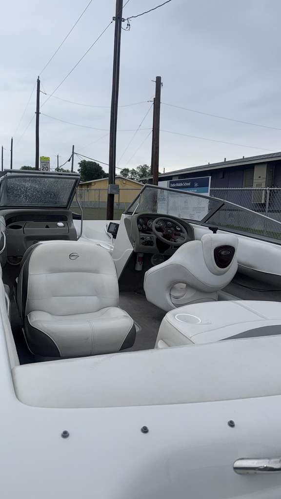 White convertible car interior with cream seats parked outdoors under an overcast sky