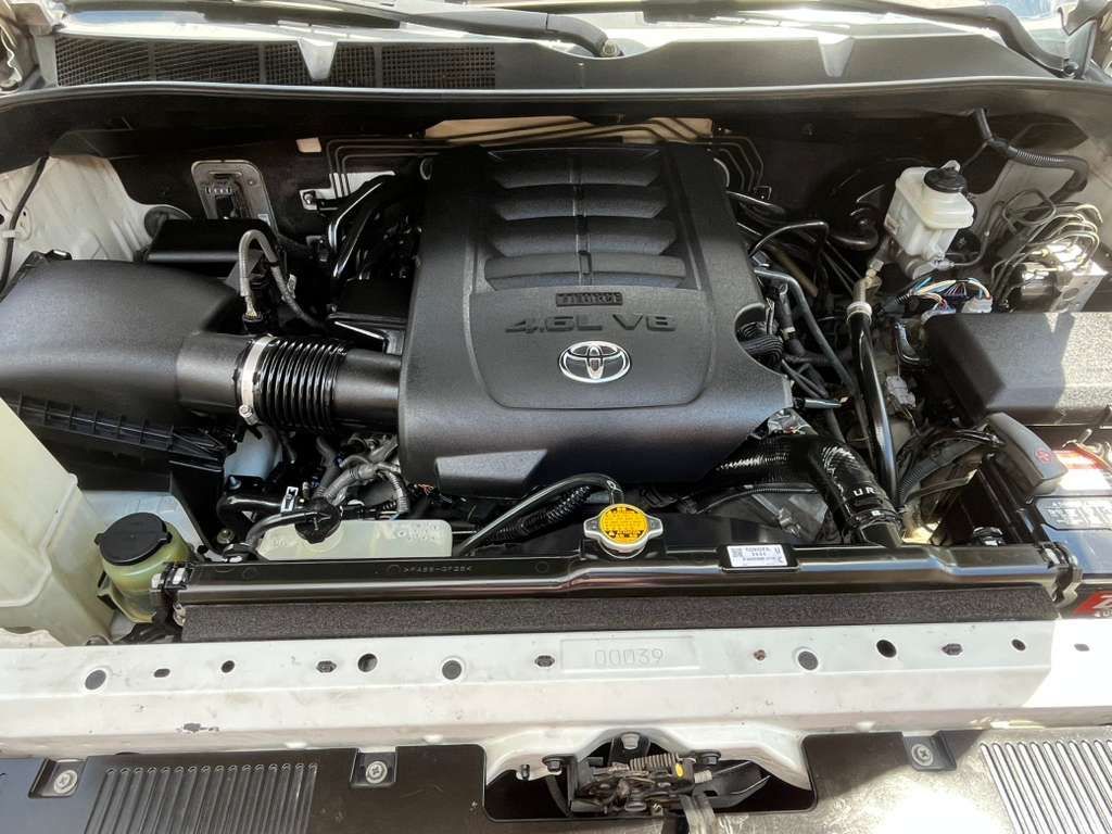 Close-up of a Toyota engine bay with black engine cover and visible hoses.
